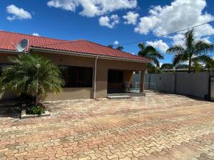 a house with a red roof and a brick patio at The 'C' Apartments in Mansa