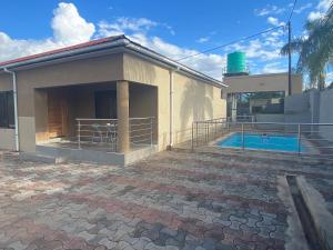 a house with a patio and a swimming pool at The 'C' Apartments in Mansa