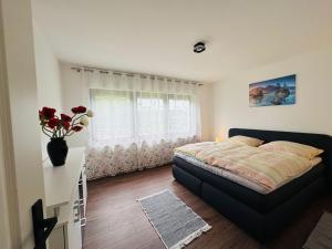 a bedroom with a bed and a vase of flowers at Haus-Elena-Wohnung-7C in Bestwig