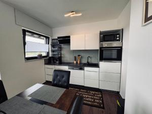 a kitchen with white cabinets and a table and a microwave at Haus-Elena-Wohnung-7C in Bestwig