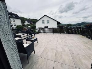a patio with two benches and a fence at Haus-Elena-Wohnung-7C in Bestwig