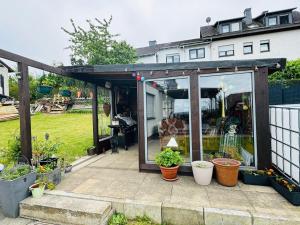 a greenhouse with potted plants on a patio at Haus-Elena-Wohnung-7C in Bestwig +9 photos