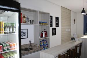 a kitchen with a counter and a refrigerator at Hotel Irmãos Vaz Br 116 - Entronc. De Jaguaquara in Jaguaquara