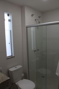 a bathroom with a toilet and a glass shower at Hotel Irmãos Vaz Br 116 - Entronc. De Jaguaquara in Jaguaquara