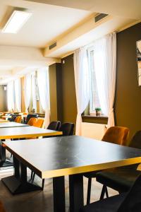 a row of tables and chairs in a room with windows at Hotel Restaurant Blumenhof in Baesweiler