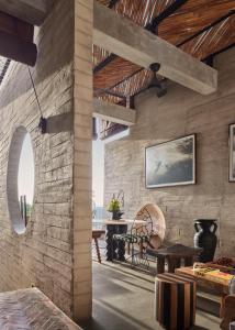 a room with a brick wall with a table and chairs at Orama Bali in Uluwatu +29 photos