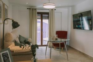 a living room with a table and a cat laying on a couch at Casa Aula Minerva Lumen 3 Dormitorios in Almedinilla
