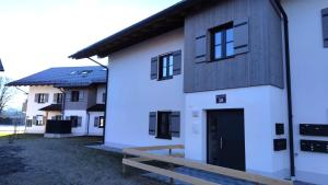 a white building with a bench in front of it at Chiemsee Apartment 17 in Übersee