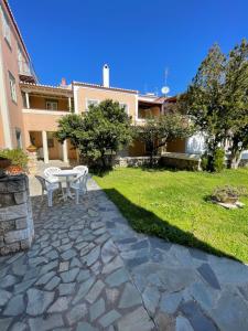 a patio with a table and chairs in a yard at PALIO LIMANI HOUSE in Spetses