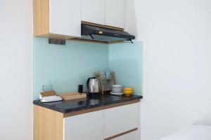 a kitchen with white cabinets and a black counter top at Board & Beyond House in Danang