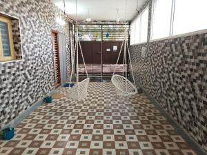 a room with two chairs and a porch with a swing at VPR Guest House in Yelagiri +55 photos