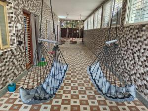 a room with two hammocks hanging from a wall at VPR Guest House in Yelagiri