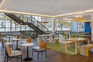 a restaurant with tables and chairs and a staircase at Spark By Hilton Montreal Midtown in Montreal