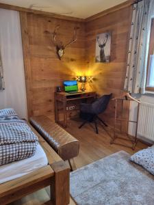 a bedroom with a bed and a desk with a laptop at Ferienwohnung Ehring in Kiefersfelden