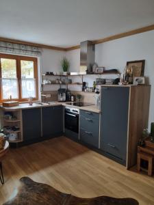a kitchen with blue cabinets and a stove top oven at Ferienwohnung Ehring in Kiefersfelden