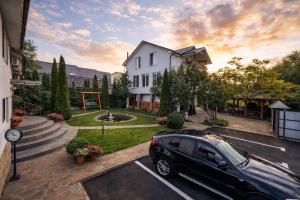 a car parked in a parking lot in front of a house at Gusarskiy Hotel and Apartment in Kyiv