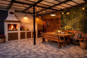a patio with a wooden table and a fireplace at Gusarskiy Hotel and Apartment in Kyiv
