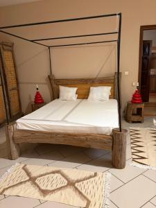 a bedroom with a bed with a wooden frame at Luciana annexe in Mbour +32 photos