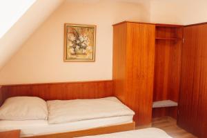 a bedroom with a bed and a wooden cabinet at Hotel Restaurant Blumenhof in Baesweiler +35 photos