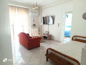 a bedroom with a bed and a couch and a chair at Sweet Suites in Amalias