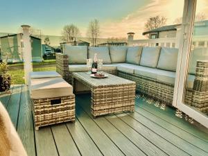 a patio with a couch and a table on a deck at Static in Peak District Ashbourne Heights Derbyshire Play Park Indoor Pool in Tissington