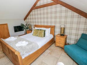 a bedroom with a bed and a blue couch at Willow Apartment - Gower in Swansea