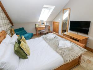 a bedroom with a large bed and a television at Willow Apartment - Gower in Swansea