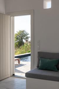 a living room with a couch and a sliding glass door at Villa AVRA, a serene Cycladic villa with private pool overlooking the Aegean Sea in Batsi +41 photos