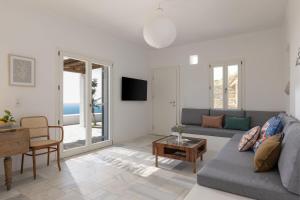 a living room with a couch and a table at Villa AVRA, a serene Cycladic villa with private pool overlooking the Aegean Sea in Batsi