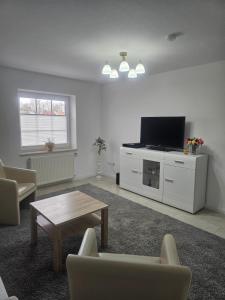 a living room with a tv and a coffee table at Ferienwohnung" Julia"in Norden in Norden
