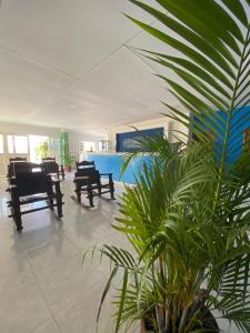 a room with a table and chairs and a plant at Hotel Palacio Real in Curumaní