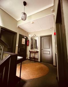a hallway with a door and a rug and a mirror at Hotel Le Ponteil in Antibes