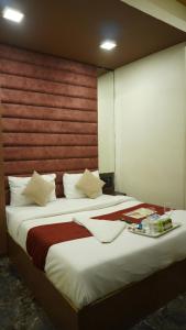 a bedroom with a large bed with a wooden headboard at Near Beach HOTEL - VERSOVA INN in Jāmb