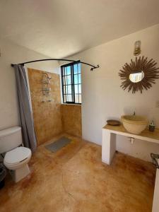 ein Badezimmer mit Toilette, Waschbecken und Spiegel in der Unterkunft Ancón Vistamar in La Paz + 7 Fotos