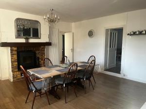 a dining room with a table and chairs and a fireplace at Gîte de Lasdoumingeas in Ladignac-le-Long