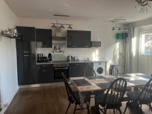 a kitchen with a table and a table and chairs at Gîte de Lasdoumingeas in Ladignac-le-Long +7 photos