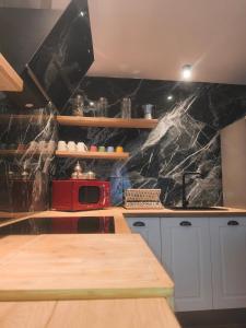 a kitchen with a counter and a red microwave at La fulla verda in San Martín de Tous