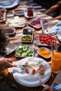 a wooden table topped with plates of food and fruit at Lilium Rooms in Çeşme