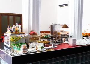 a buffet line with various food items on a counter at MJ Grand Hotel in East Legon