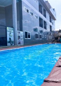 a large blue swimming pool in front of a building at MJ Grand Hotel in East Legon