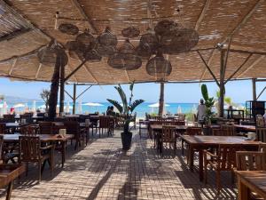 a restaurant with tables and chairs and a view of the ocean at Lilium Rooms in Çeşme