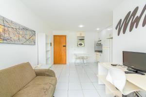 a living room with a couch and a table and a tv at Premier Residence Residencial em Brasília 67961 in Brasília