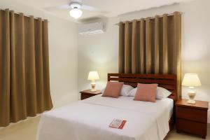 a bedroom with a bed with two lamps and curtains at Spacious Home with Private Pool in San Felipe de Puerto Plata +31 photos