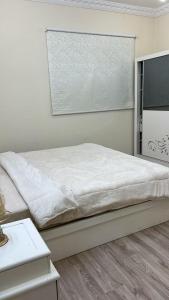 a white bedroom with a bed and a television at شقه مفروشه in Hail +11 photos