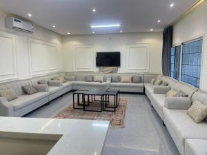 a large living room with couches and a tv at شقه مفروشه in Hail