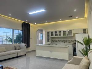 a living room with a kitchen and a couch at شقه مفروشه in Hail
