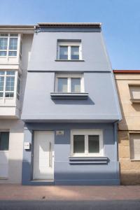 a house with a blue door and two windows at Casa Cuca O Grove in O Grove
