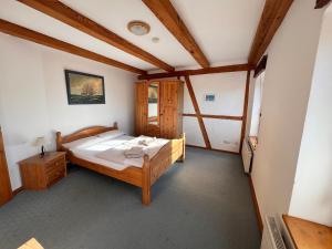 a bedroom with a wooden bed in a room at Pension Schmelzer in Kägsdorf