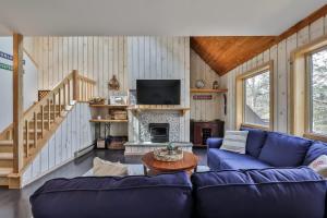 a living room with blue couches and a fireplace at Windham Mountain Condo with Deck & Stunning Views in Windham