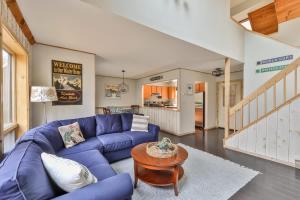a living room with a blue couch and a table at Windham Mountain Condo with Deck & Stunning Views in Windham